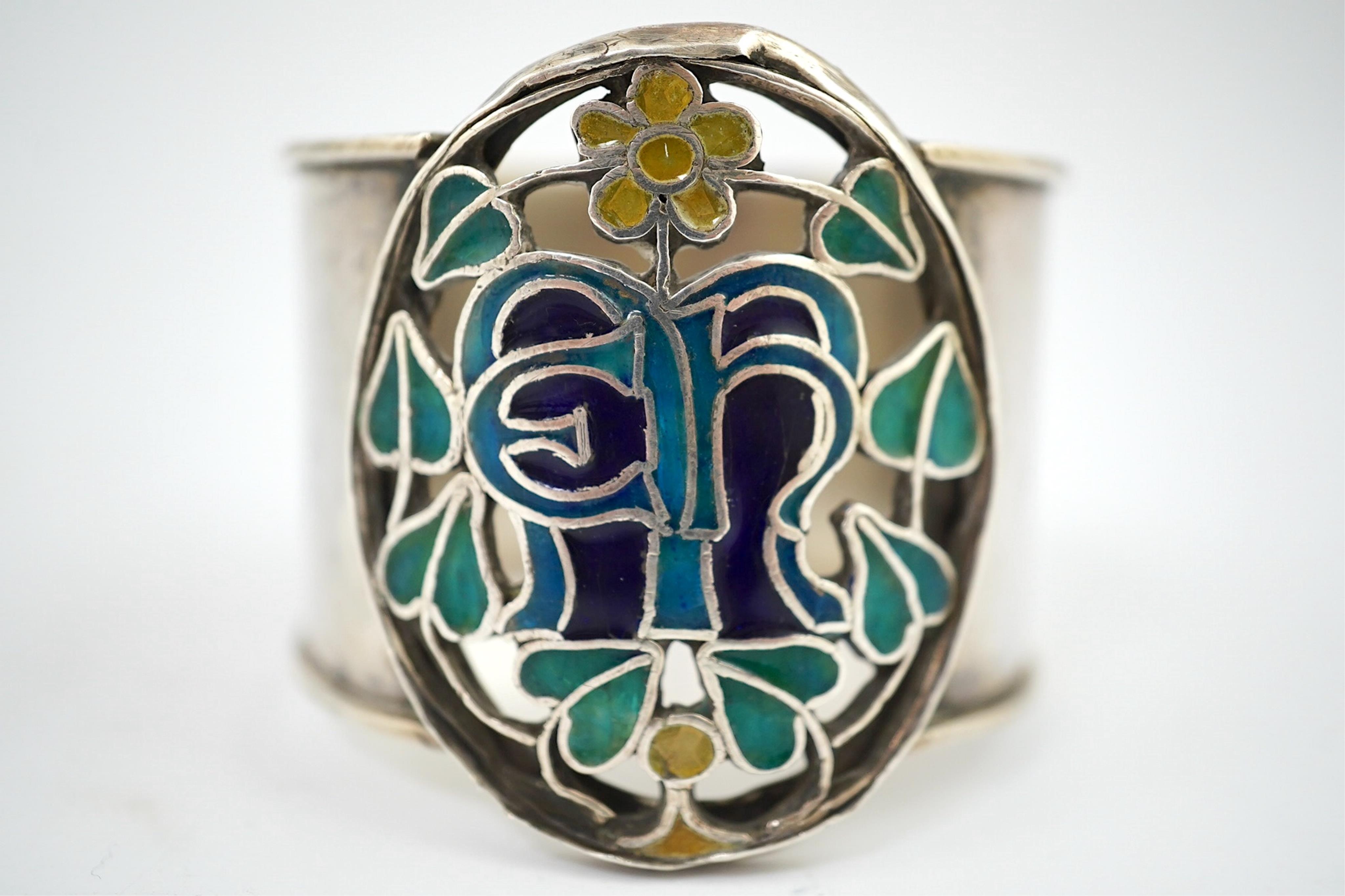 An Arts and Crafts silver and enamel napkin ring, maker’s mark LH, Birmingham 1938, 4.5cm high. Condition - fair